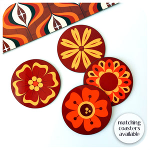 A set of four 70s style retro flower coasters on a white background next to a 70s style placmeat. Text in bottom right corner reads "matching coasters available" | The Inkabilly Emporium