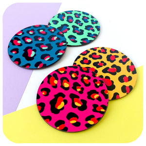 A set of four multi-coloured Leopard Print coasters sit in pairs against a white, yellow and lilac background | The Inkabilly Emporium